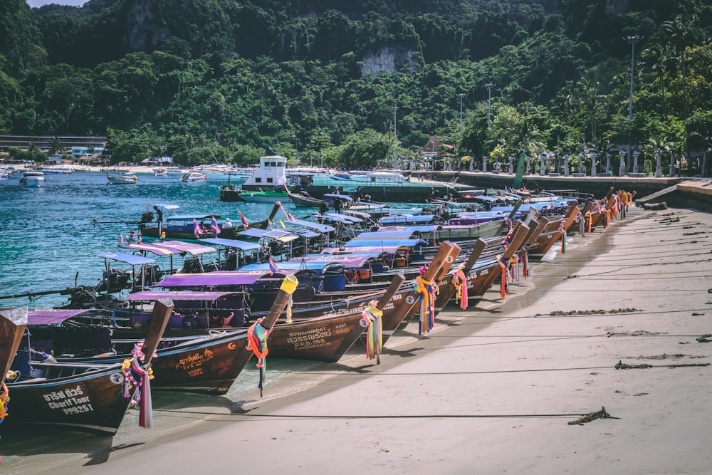 brown wooden boats on sea shore during daytime