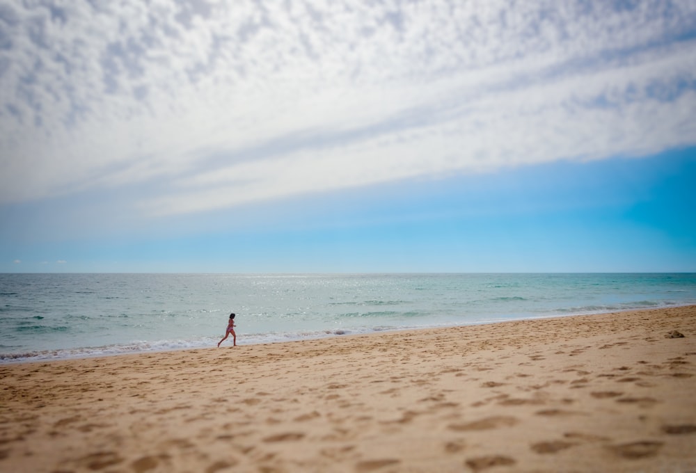 pessoa correndo na praia durante o dia