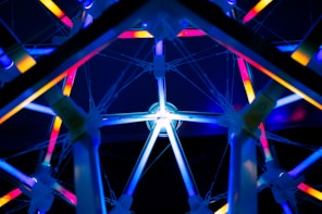 a ferris wheel lit up at night with colorful lights