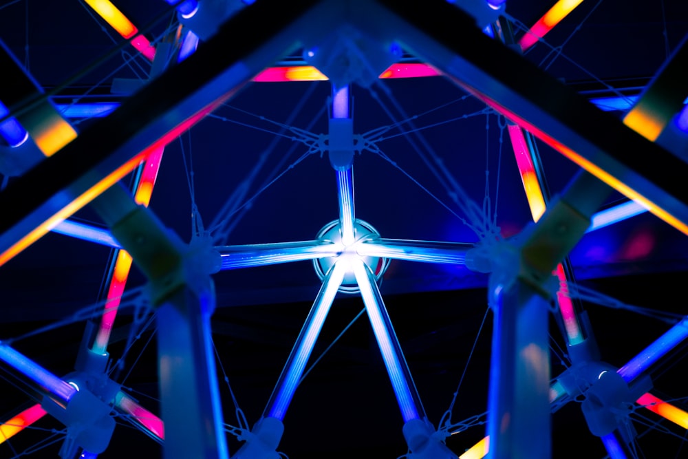 Une grande roue éclairée la nuit par des lumières colorées