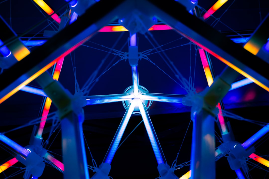 a ferris wheel lit up at night with colorful lights,