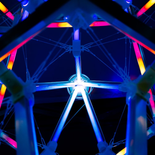 a ferris wheel lit up at night with colorful lights