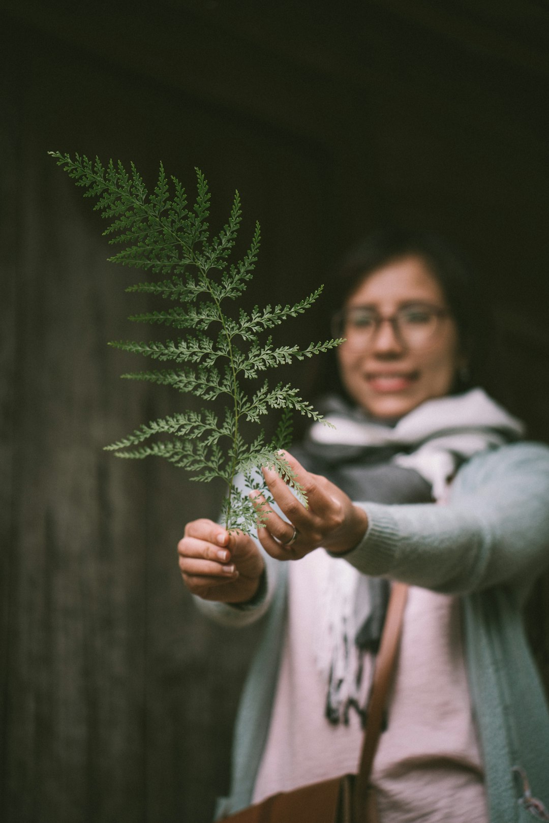 woman holding green leaf while smiling