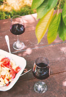 Glasses of red and white wine on a wooden table, ready to be enjoyed.