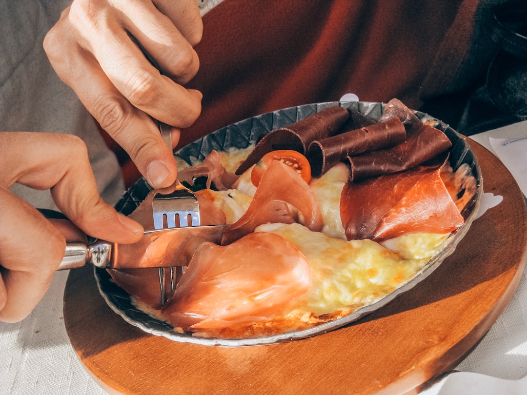 person slicing dish on round gray ceramic plate