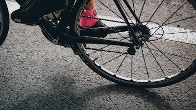 Close-up of a cyclist's legs pedaling fast on a road bike.