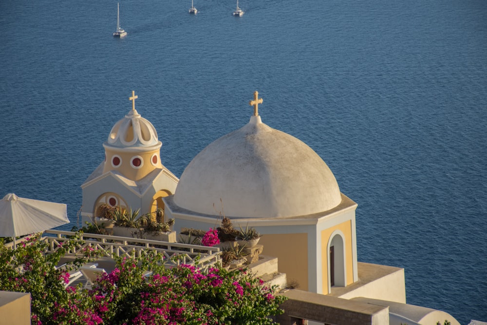 white and yellow church near ocean water during daytime