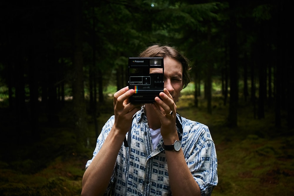 man holding a black instant camera