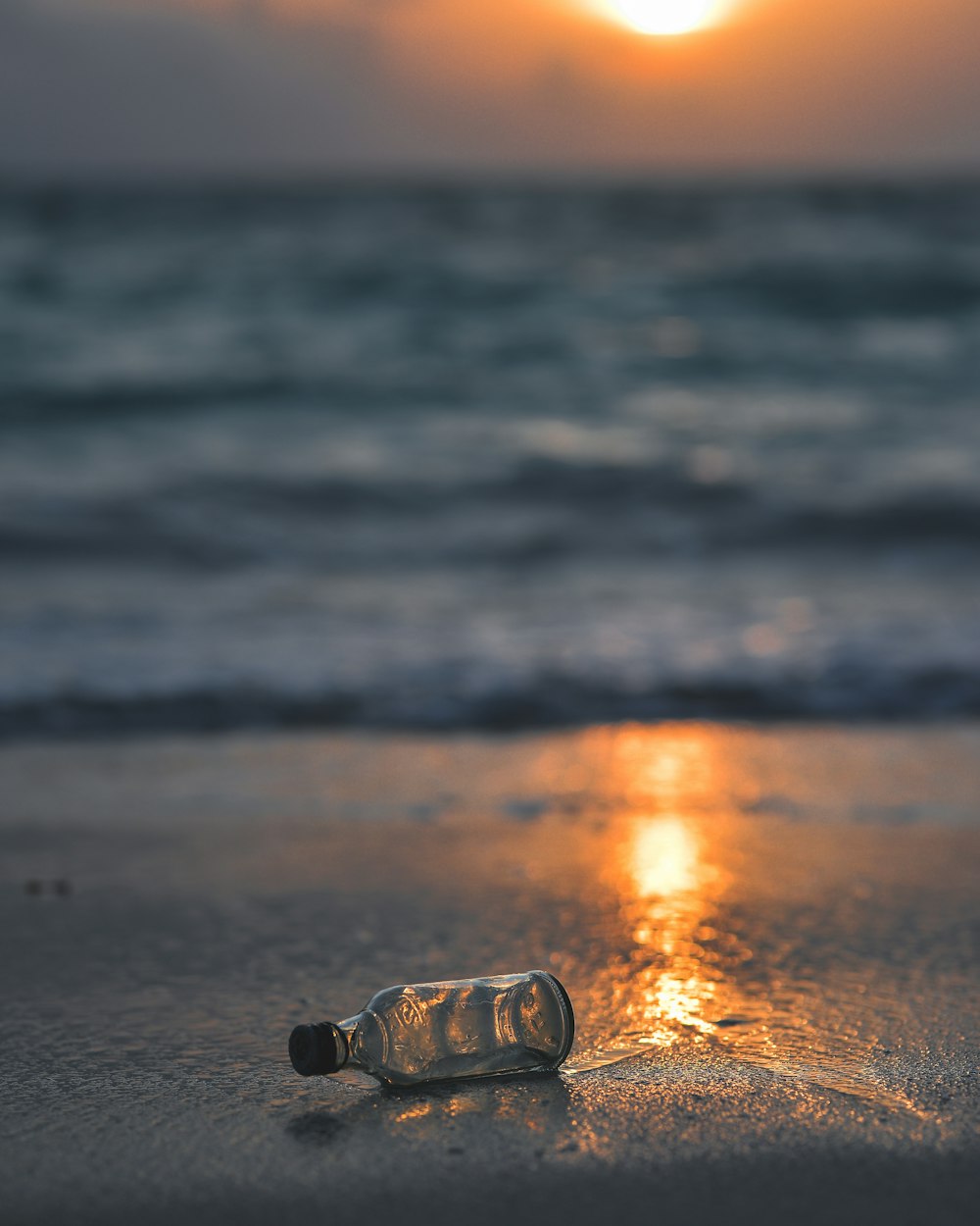 clear glass bottle on seashore