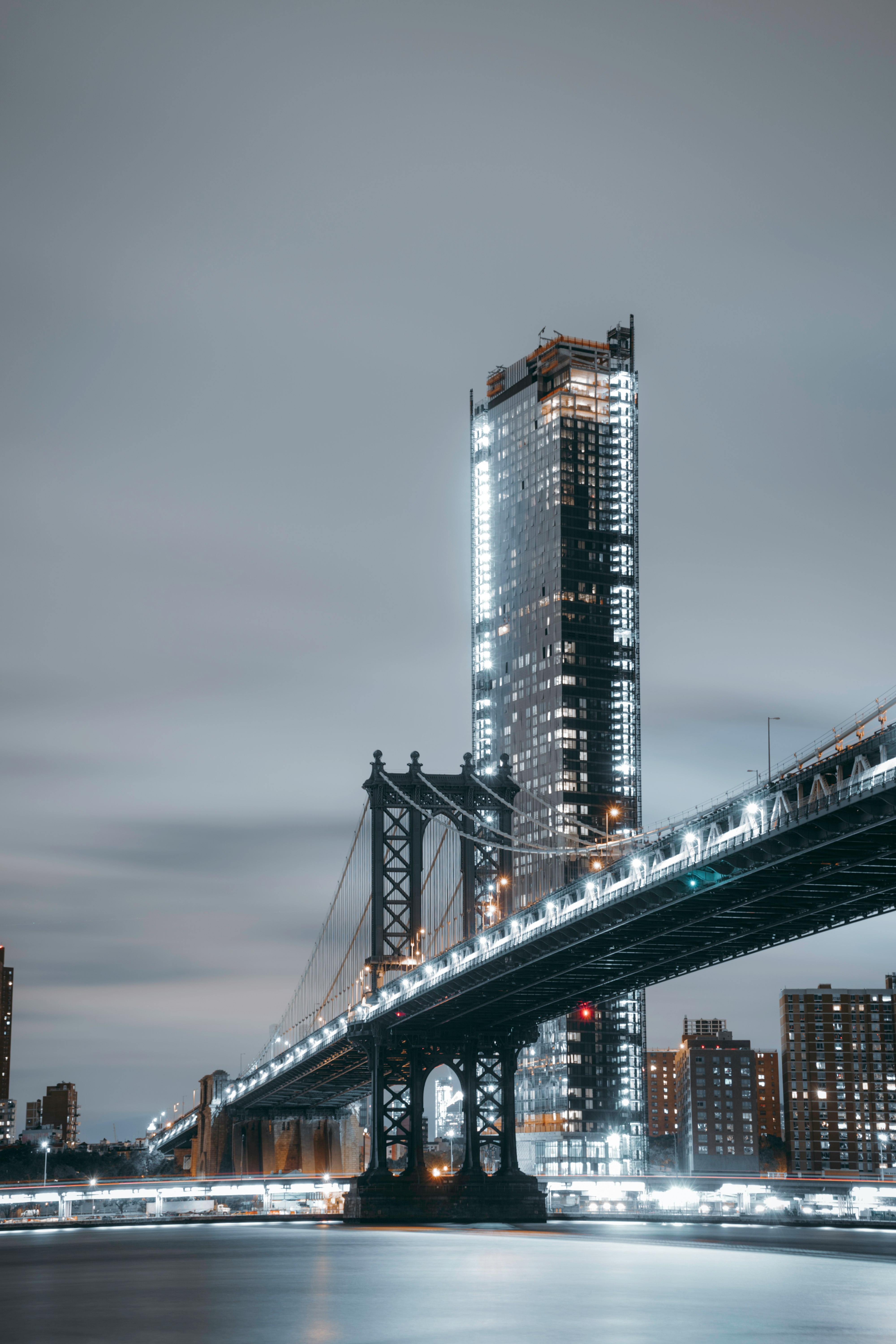 concrete bridge near high-rise building at cloudy sky