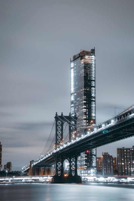 concrete bridge near high-rise building at cloudy sky in Brooklyn Bridge Park United States