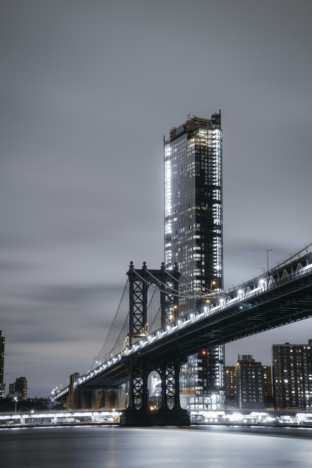 concrete bridge near high-rise building at cloudy sky