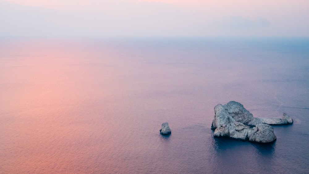 aerial photography of brown rock formation near body of water