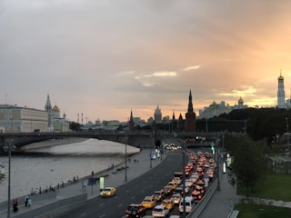 A vibrant street scene in Budapest showcasing the iconic Chain Bridge with the Danube River at sunset.