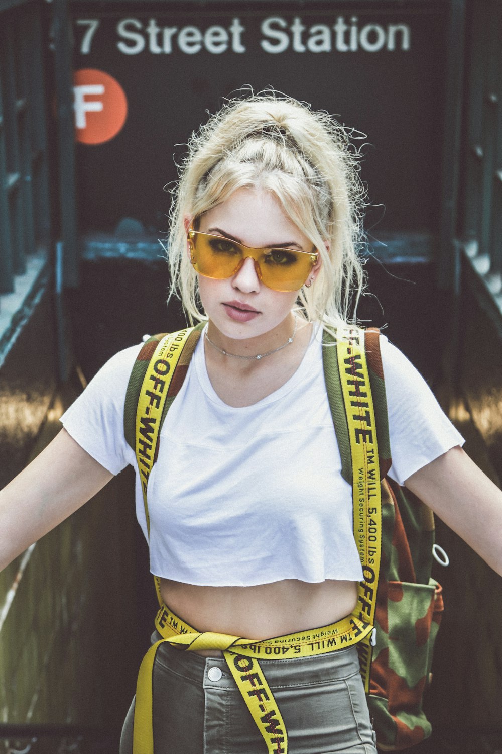 woman in white top riding escalator