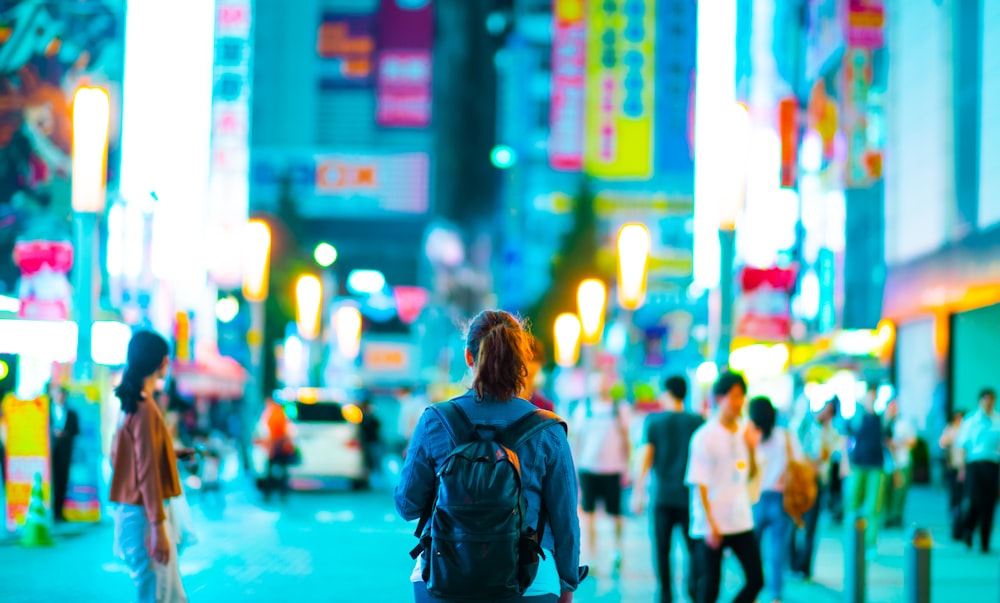 woman walks on street surrounded people