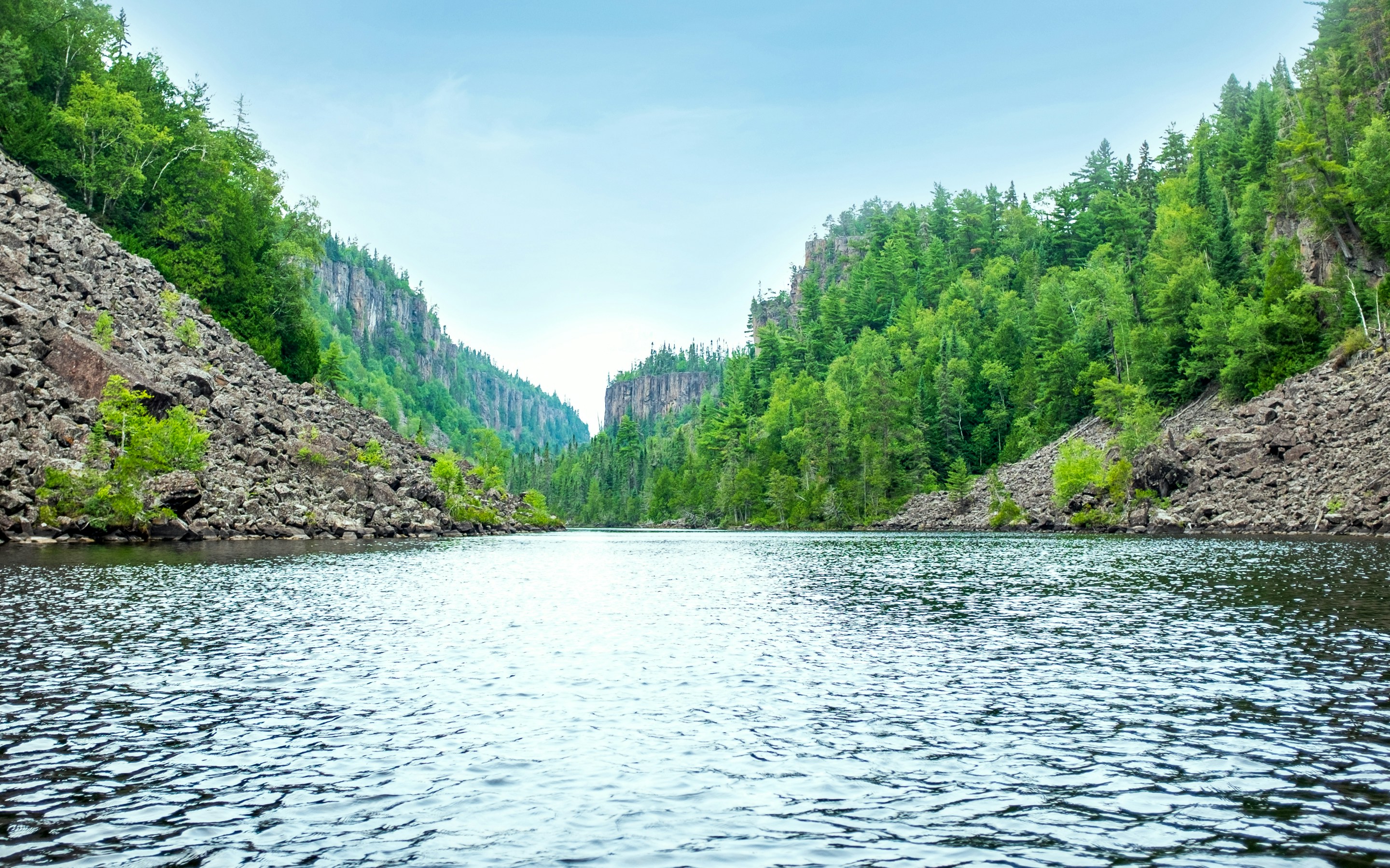 landscape photography of green leafed trees, There’s a place in north Ontario where the only sound is... the whispers of your kayak gliding through the fresh northern breeze. Hidden within a canyon, this lake has rock formations dated back billions of years. It