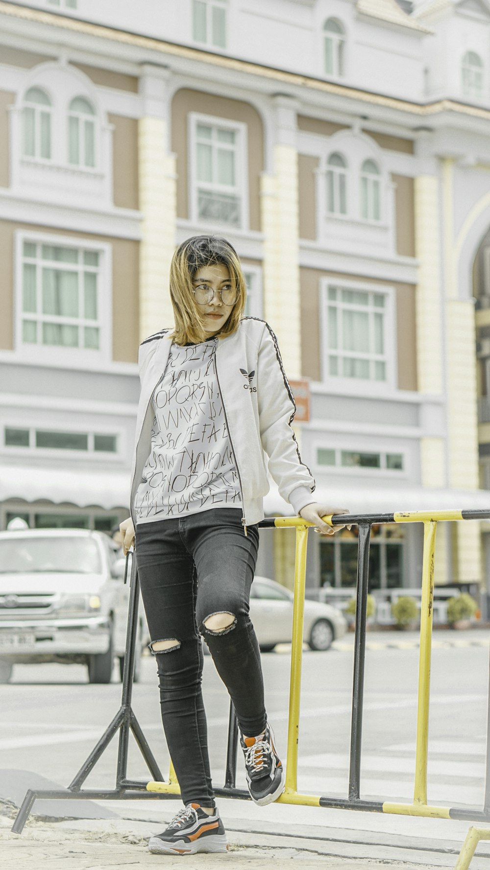 woman leaning on metal handrail front of building at daytime