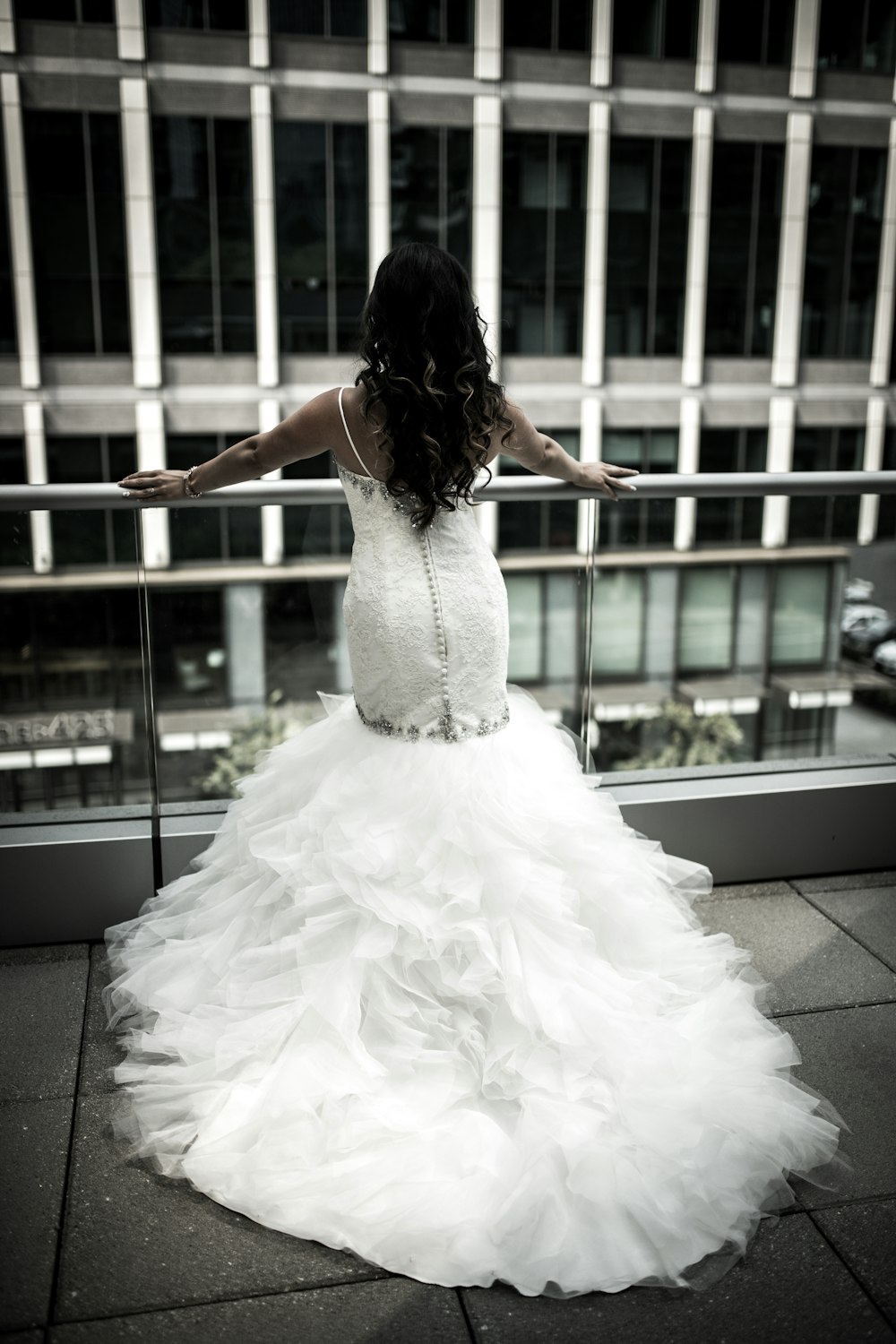 woman in white wedding dress standing in front balustrades