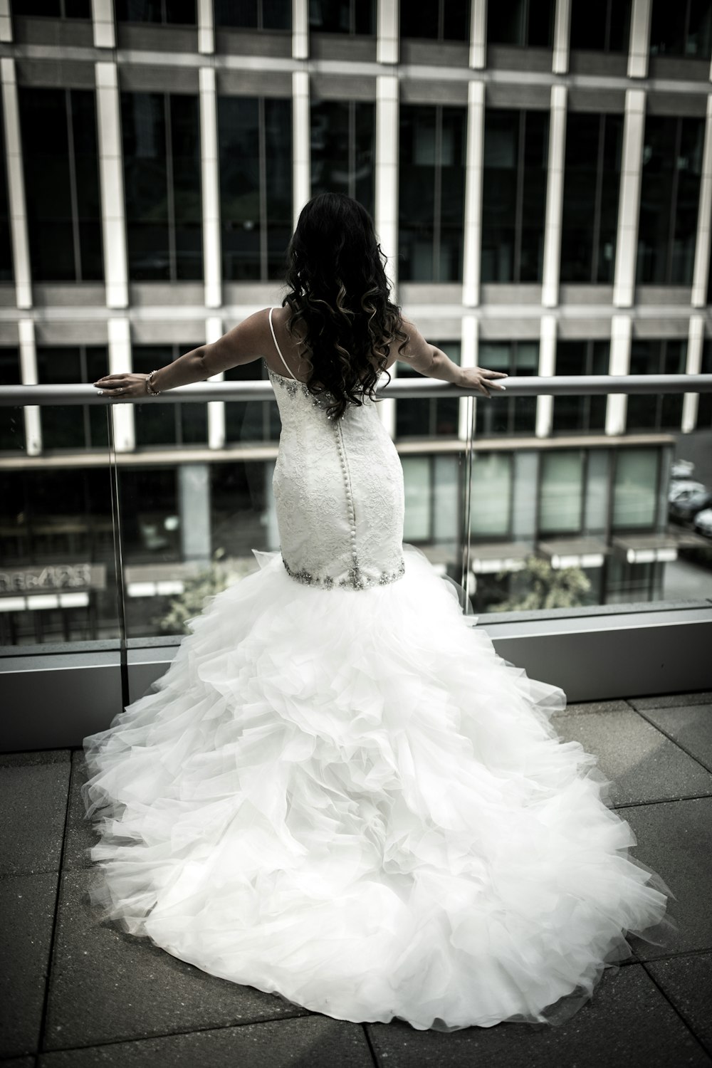 femme en robe de mariée blanche debout devant les balustrades