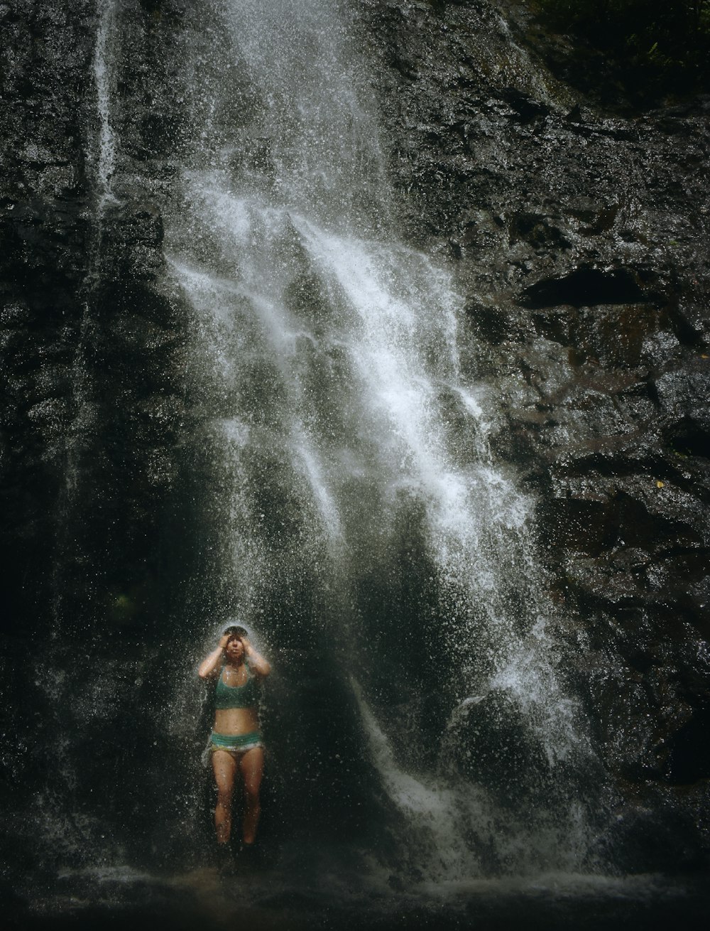 Mujer tomando un baño en cascadas