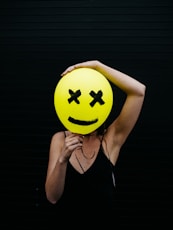 woman holding yellow and black balloon at daytime