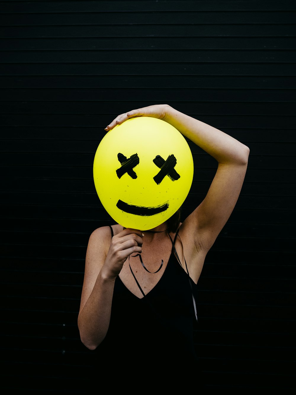 woman holding yellow and black balloon at daytime