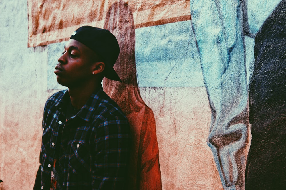 man standing beside wall with graffiti