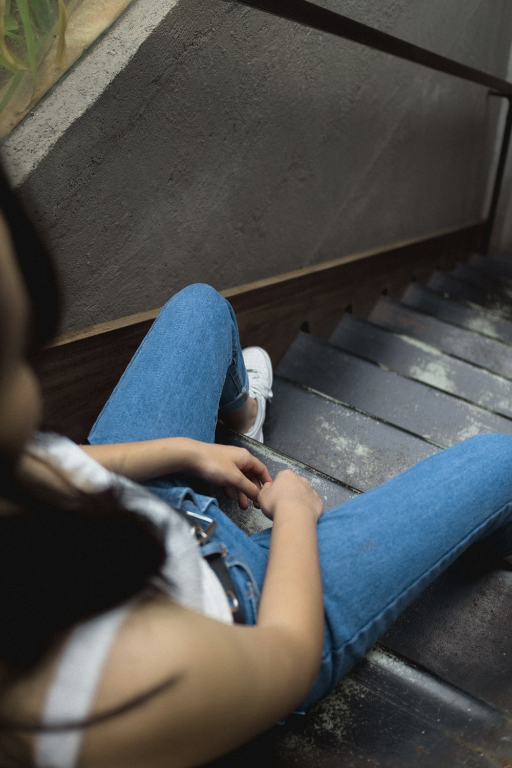 mulher sentada em escadas cinzentas