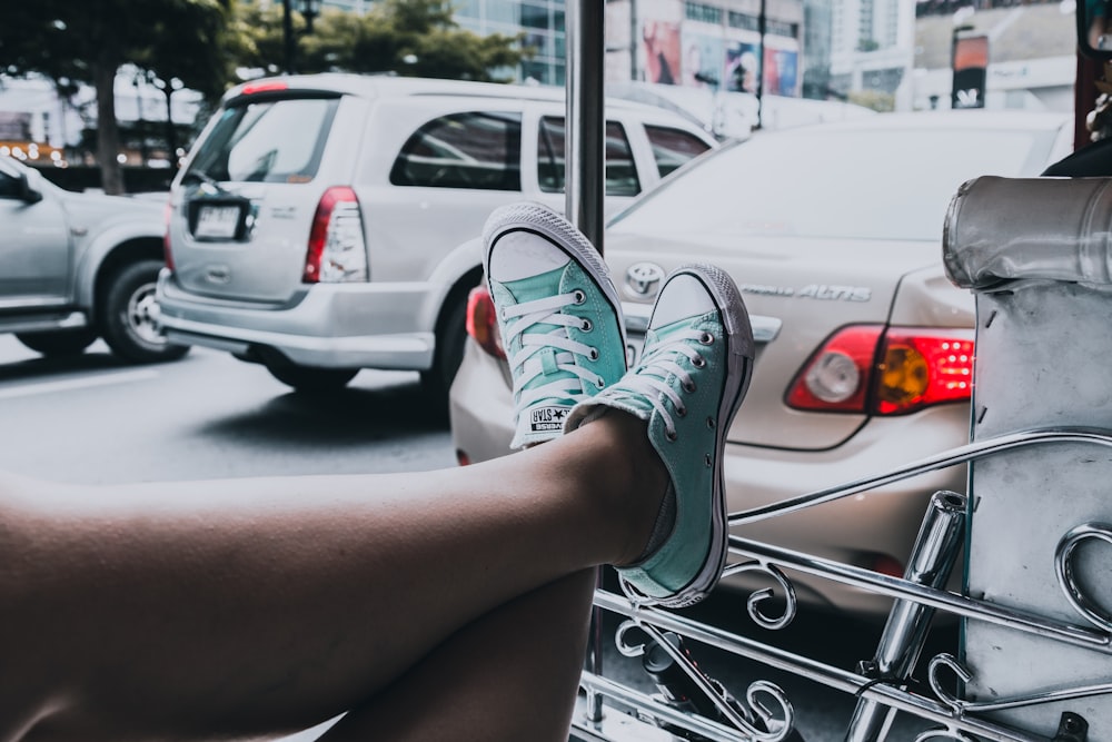 woman wearing teal-and-white Converse All-Star low-tops