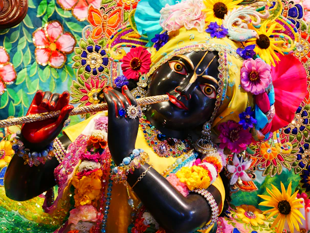 Vasanta, god of spring, surrounded by vibrant flowers and a gentle breeze.