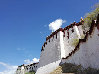 The Alcázar of Toledo standing tall against a bright blue sky.
