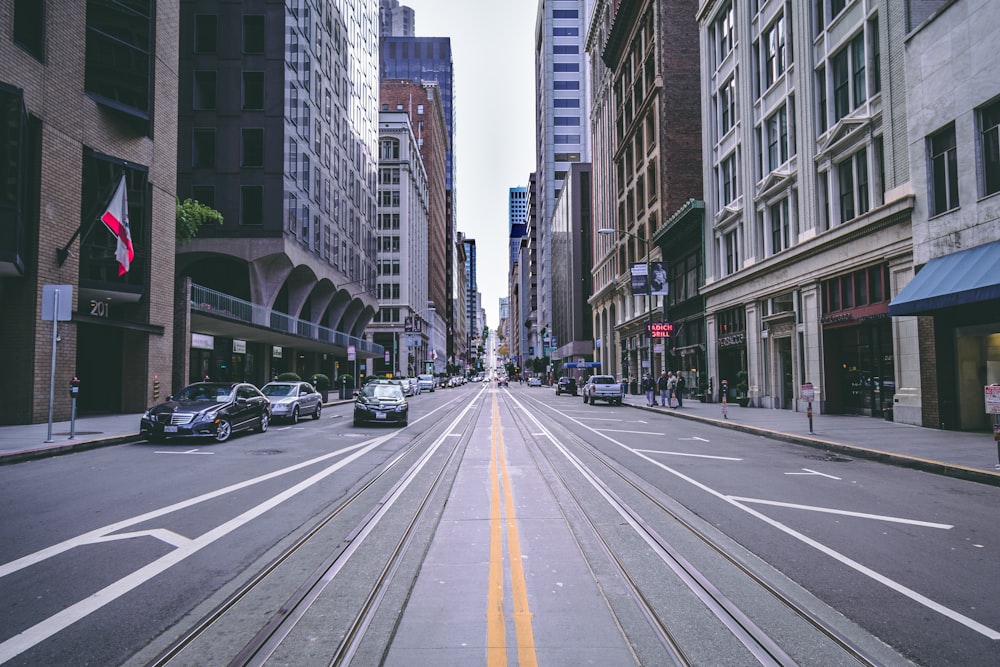 vehicles on road between high-rise buildings