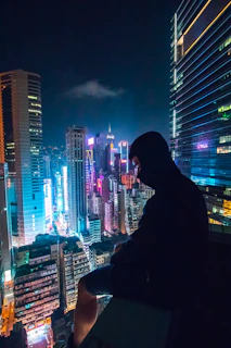 Dynamic shot of a nighttime cityscape with a person wearing a fersátil hoodie