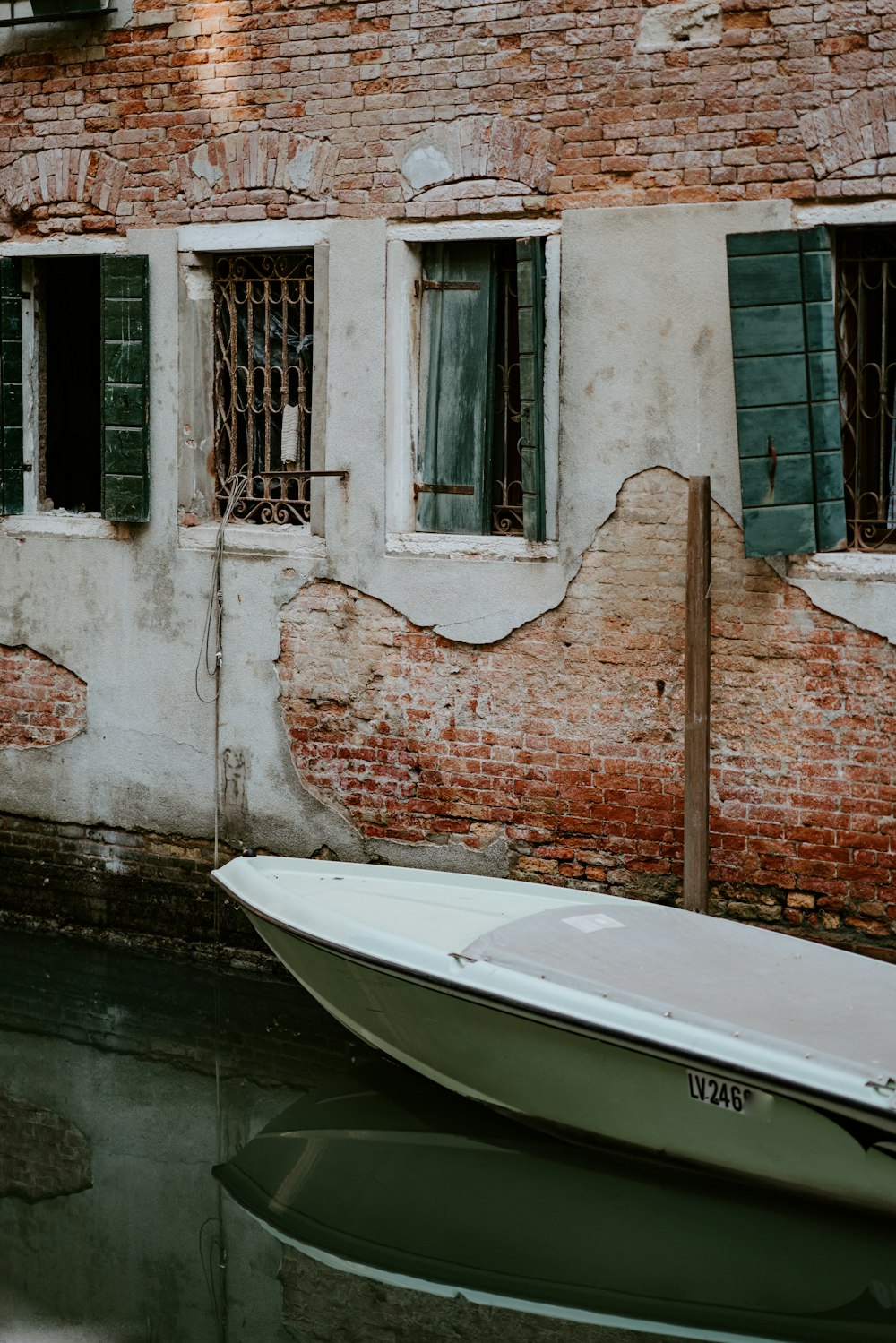 Bateau blanc à côté d’un mur de briques