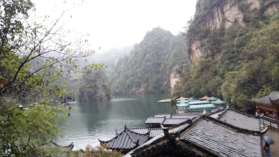 A serene landscape featuring traditional Chinese mountains and a calm river.