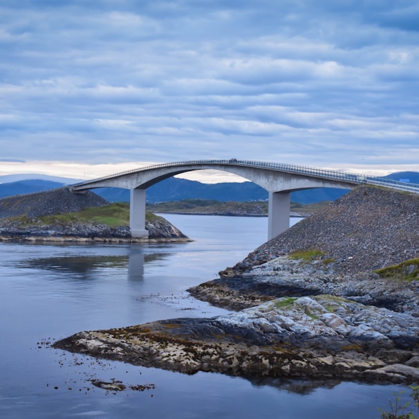 white concrete bridge under white and blue sky at daytime