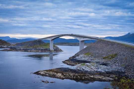 white concrete bridge under white and blue sky at daytime in The Atlantic Road Norway
