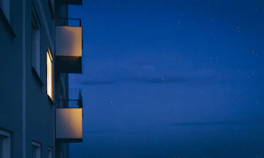 Night view of the apartment lit softly with warm lights against the starry sky.