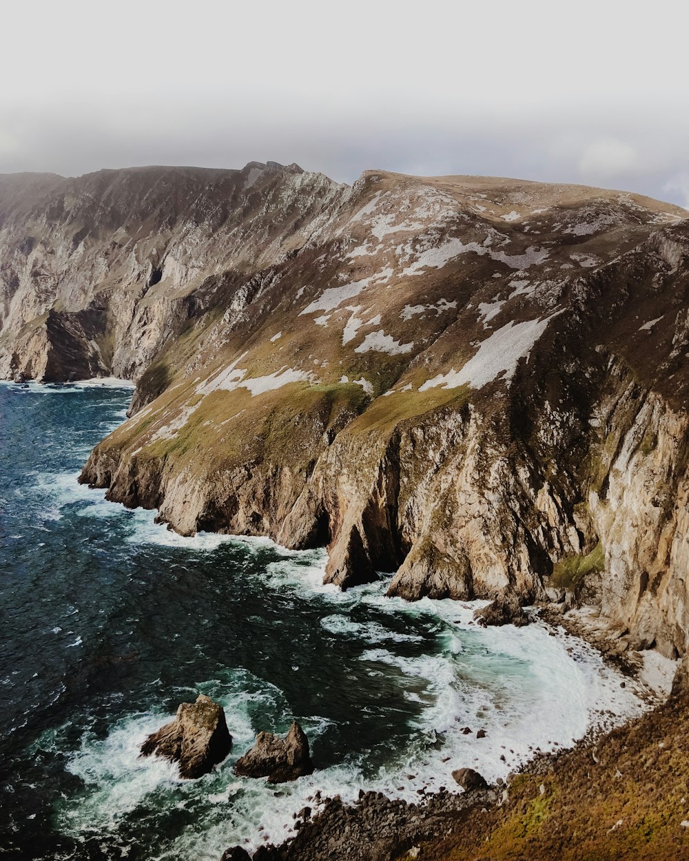 Eau de mer et falaise sous les nuages blancs