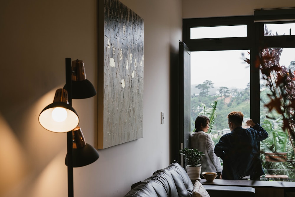 turned-on 3-head lamp near woman and man sitting on terrace