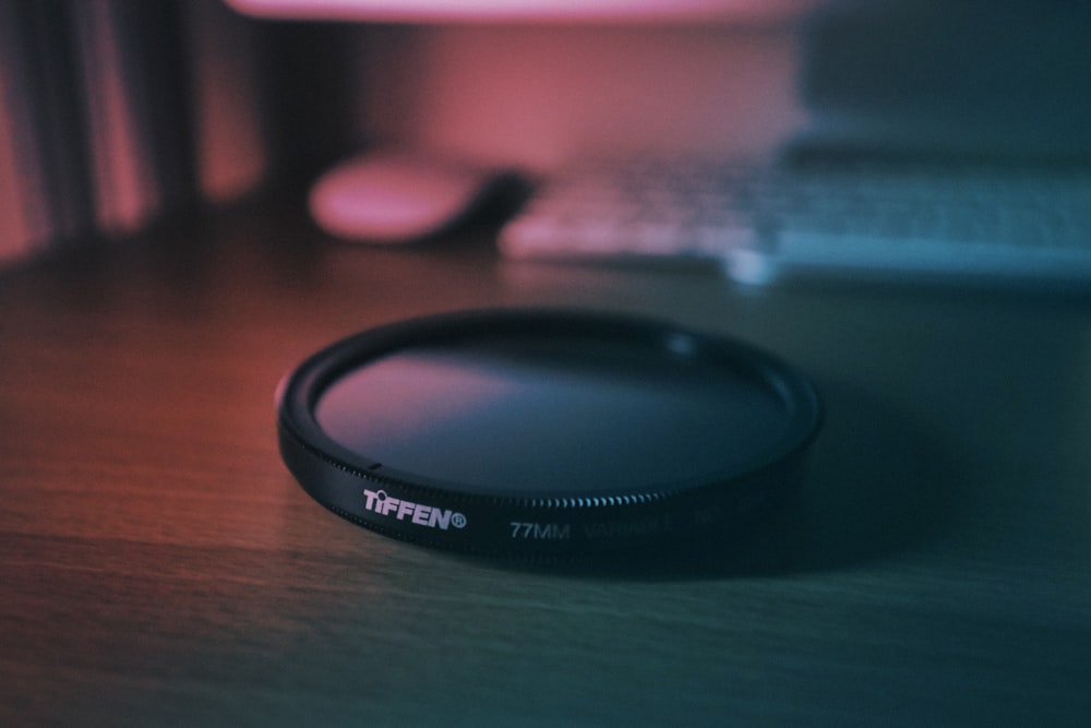 round black Tiffen cover near white computer keyboard