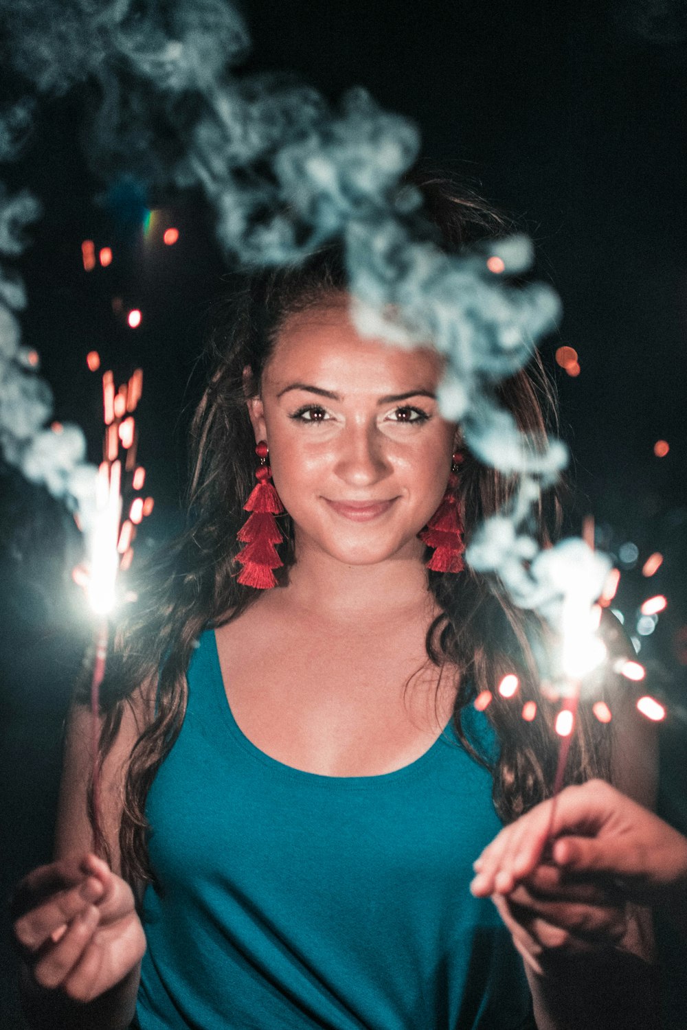 woman holding lighted sparkler taken during night time