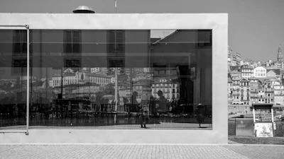 Architectural shot of a glass-walled conference room overlooking a city skyline at dusk.
