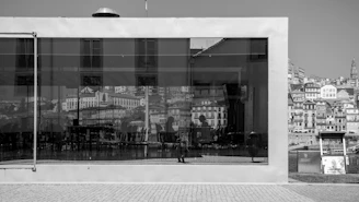 A modern window with sleek black frames reflecting a city skyline.