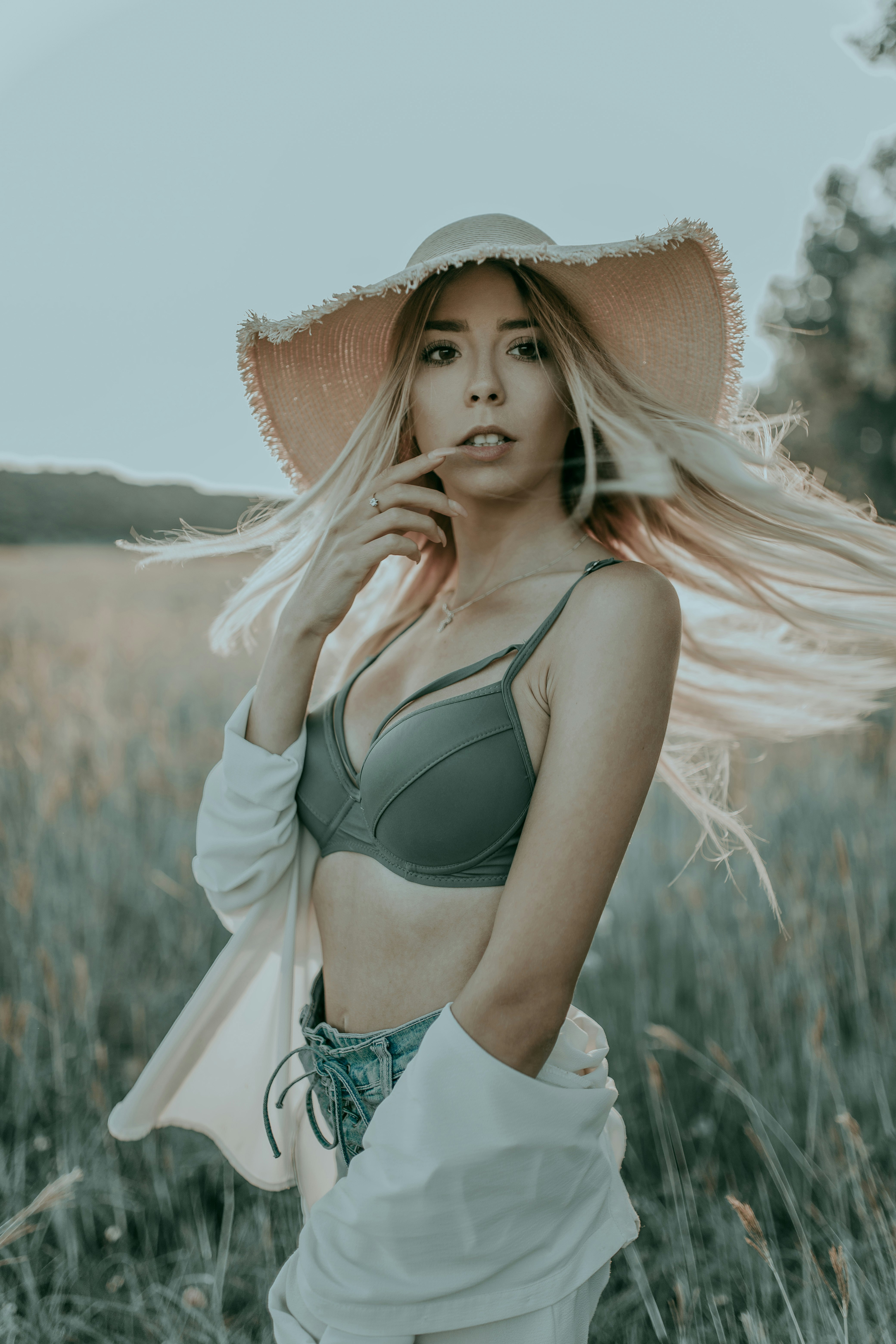 woman on surrounded by plants wearing brown sunhat