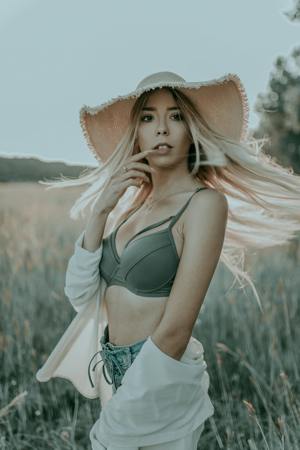 woman on surrounded by plants wearing brown sunhat