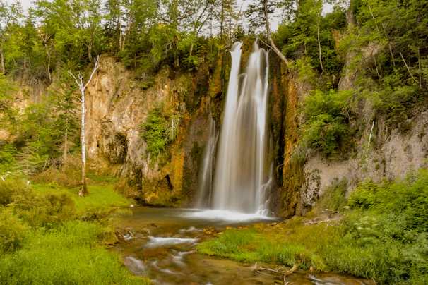 A picturesque waterfall cascading down a rocky cliff in a serene landscape.
