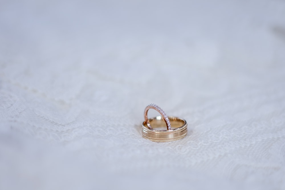 gold-colored ring on white surace