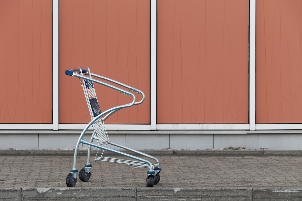 Gray shopping cart beside a wall in an empty retail space